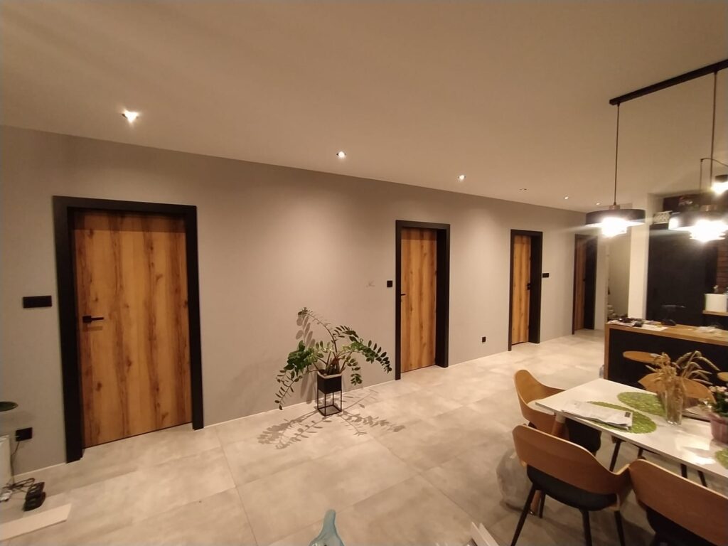 Drzwi wewnętrzne z okleiną imitującą naturalne olejowane drewno. Zdjęcie przedstawia realizację pracy Puerta Drzwi w salonie, w domu jednego z klientów.